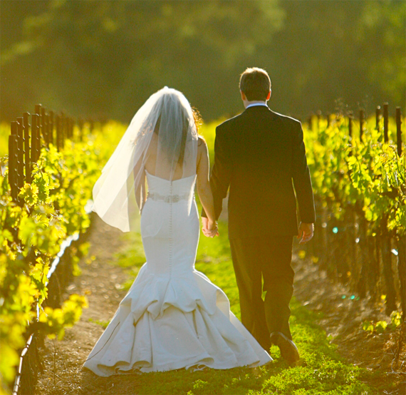 Bride and Groom walking through the vineyard