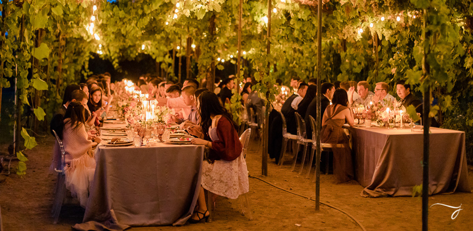 Wedding Guests Dine At A Candlelit Outdoor Wine Country Wedding Venue