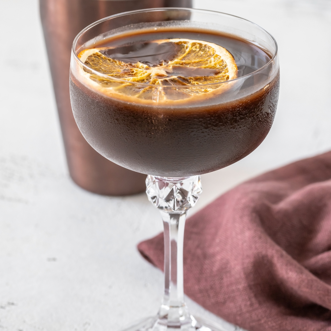 chocolate cocktail in glass with dried orange garnish